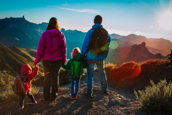 A Mother, Father and two Children hiking up a mountain.