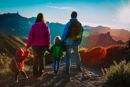 A Mother, Father and two Children hiking up a mountain.