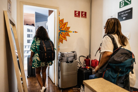 Two women entering travel accommodation.