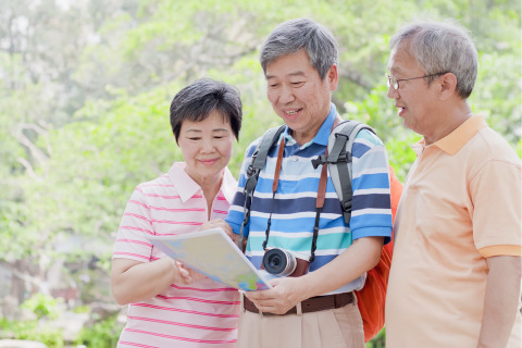 A senior group consult a map while travelling.