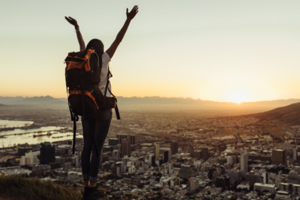 A solo travelling woman admiring a city view.