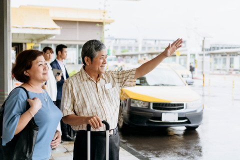 A couple hails a taxi outside the airport.