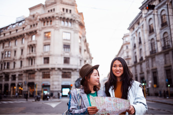 Two women exploring a new city by map.